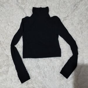 Divided black long-sleeve cropped turtleneck top.